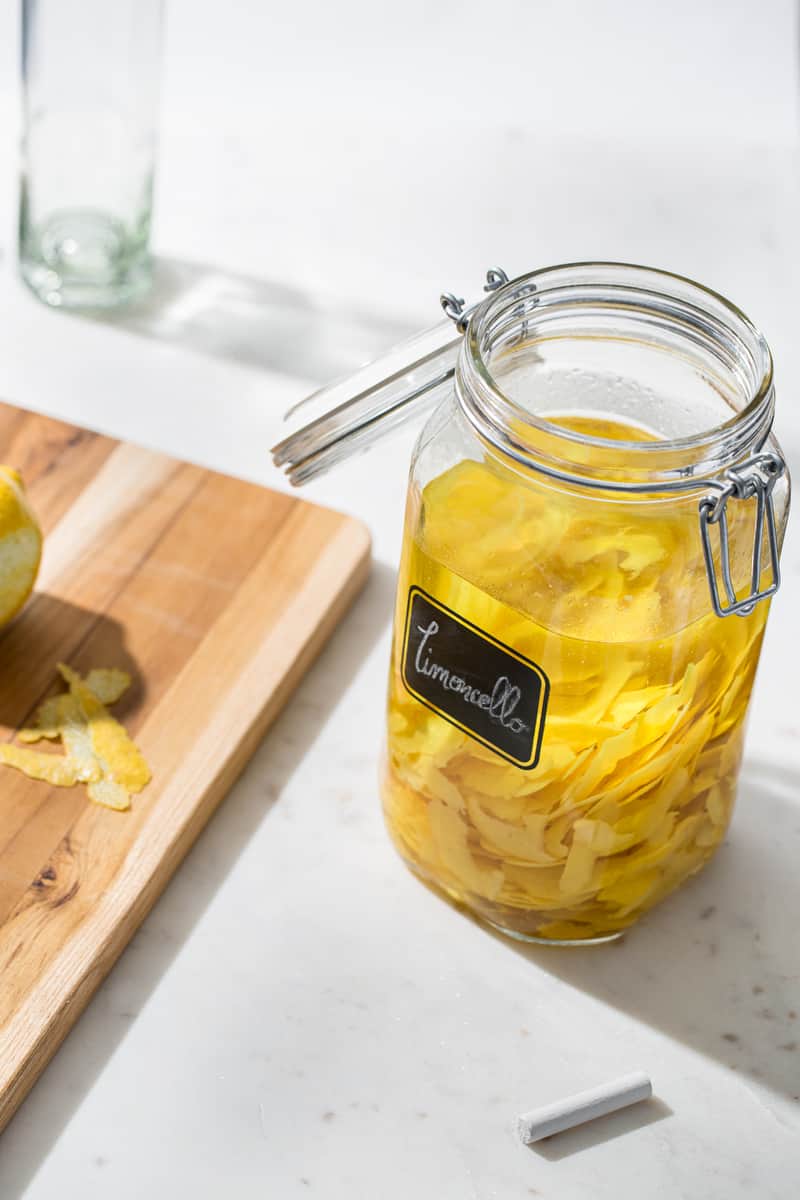 glass jar filled with alcohol and lemon rinds