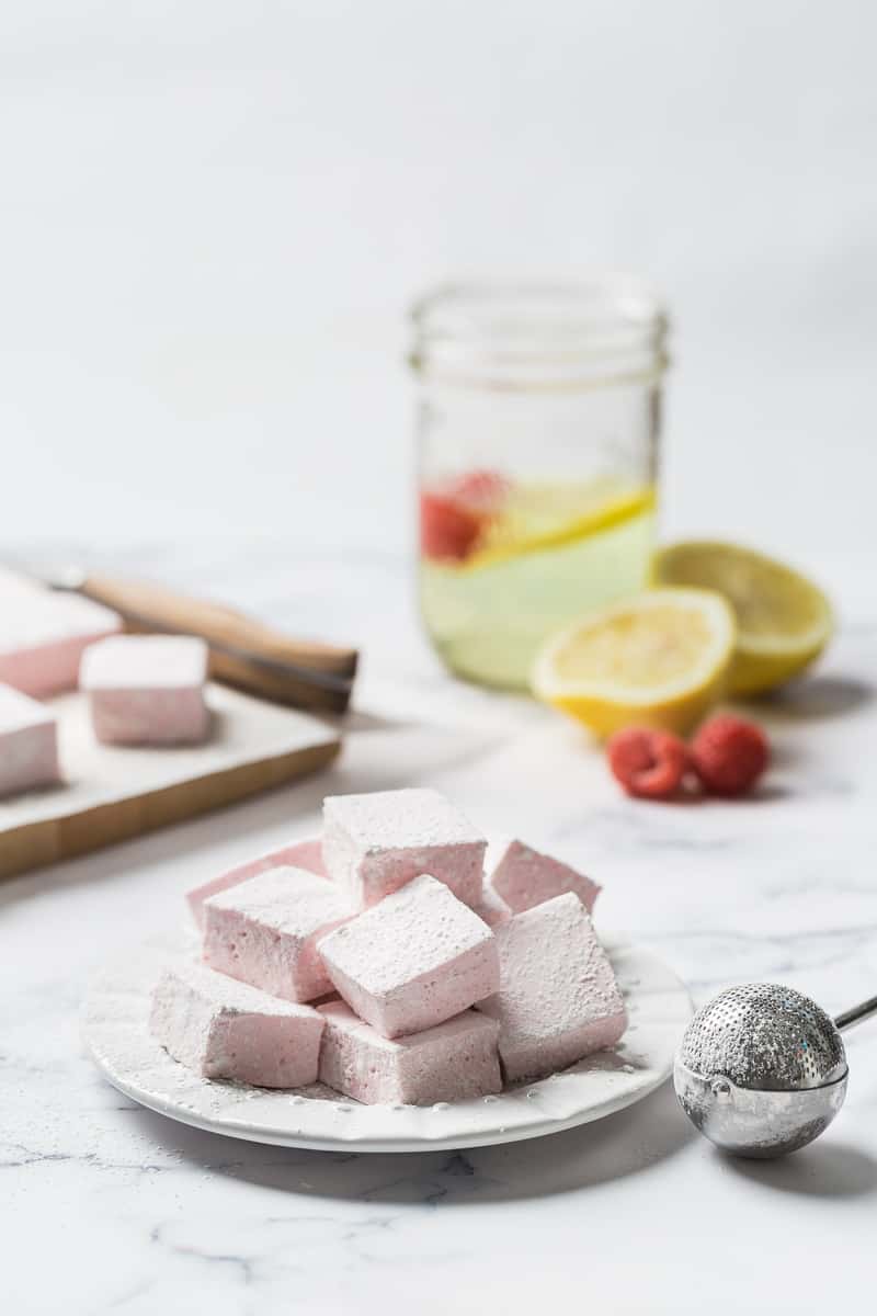 pink marshmallows on a plate with lemonade in the background