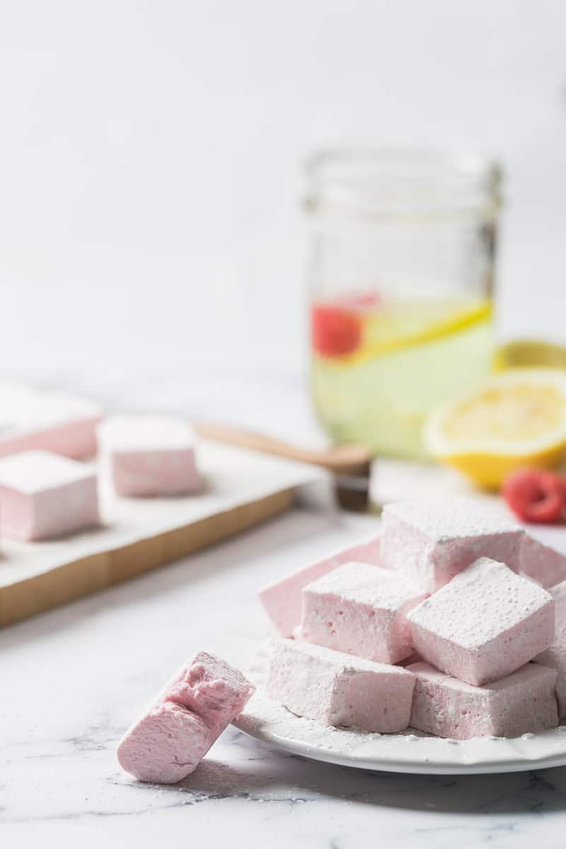 pink marshmallows on a plate with lemonade in the background