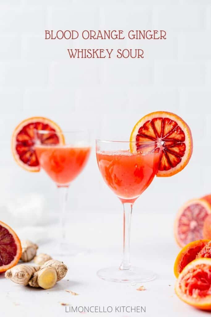 blood orange cocktails in nick and nora glasses with ginger and blood oranges around them