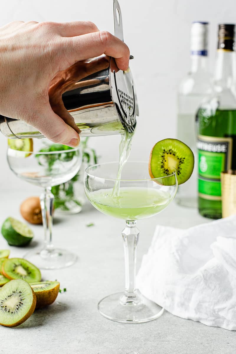 pouring daiquiri into glass from cocktail shaker