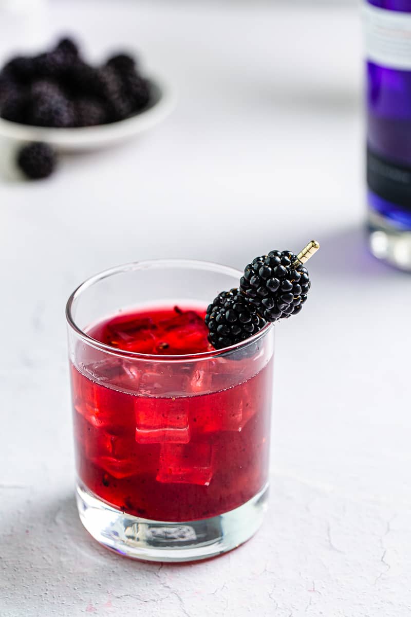 Blackberry Empress Gin Sour completed drink with blackberry garnish