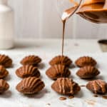 pouring chocolate glaze onto madeleines