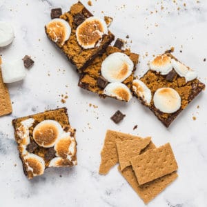 smores brownies with graham streusel, with graham crackers and marshmallows strewn about