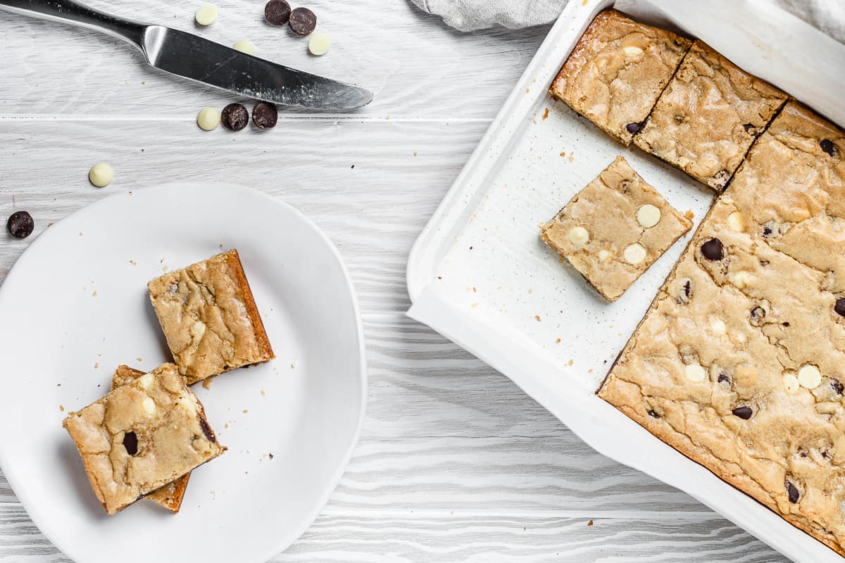 overhead shot of blondies in a baking tray and on a plate
