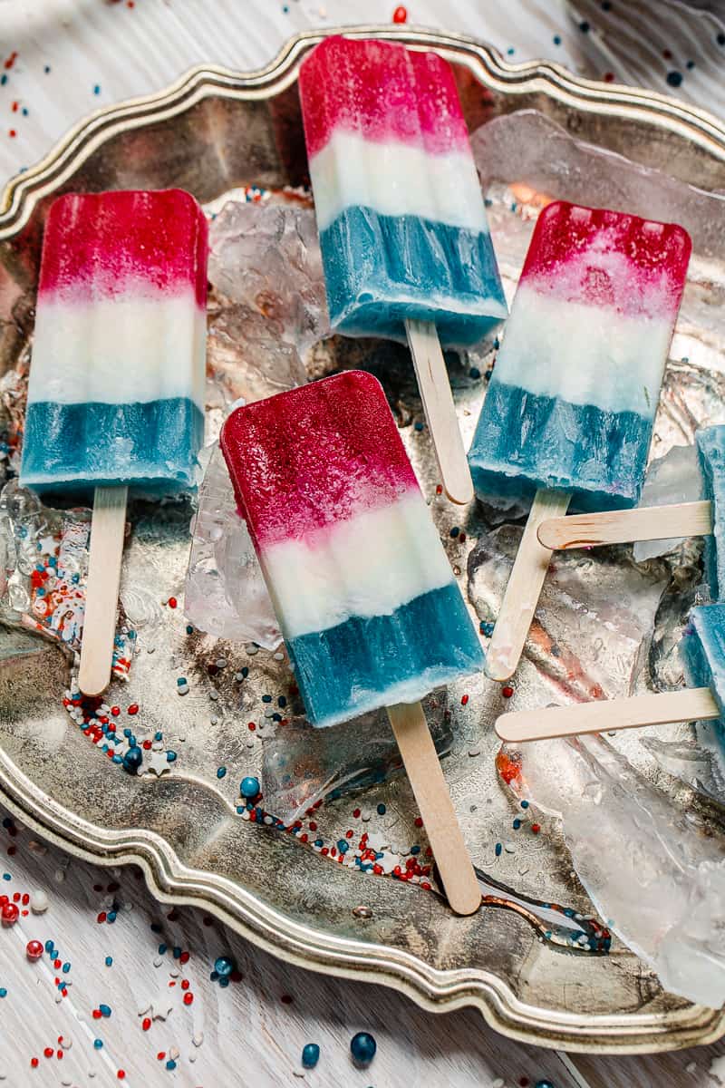 boozy firecracker popsicles on a silver tray with ice