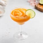 frozen smoky peach margarita in a large margarita glass