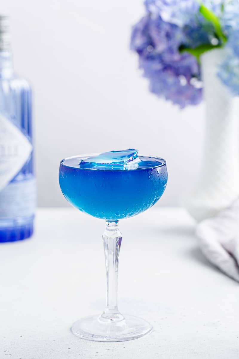 vertical shot of layered blue gin cocktail