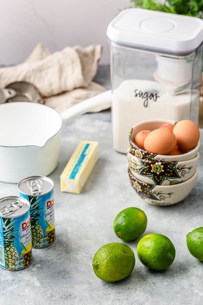 ingredients set out on the counter - limes, pineapple juice, butter, eggs, sugar