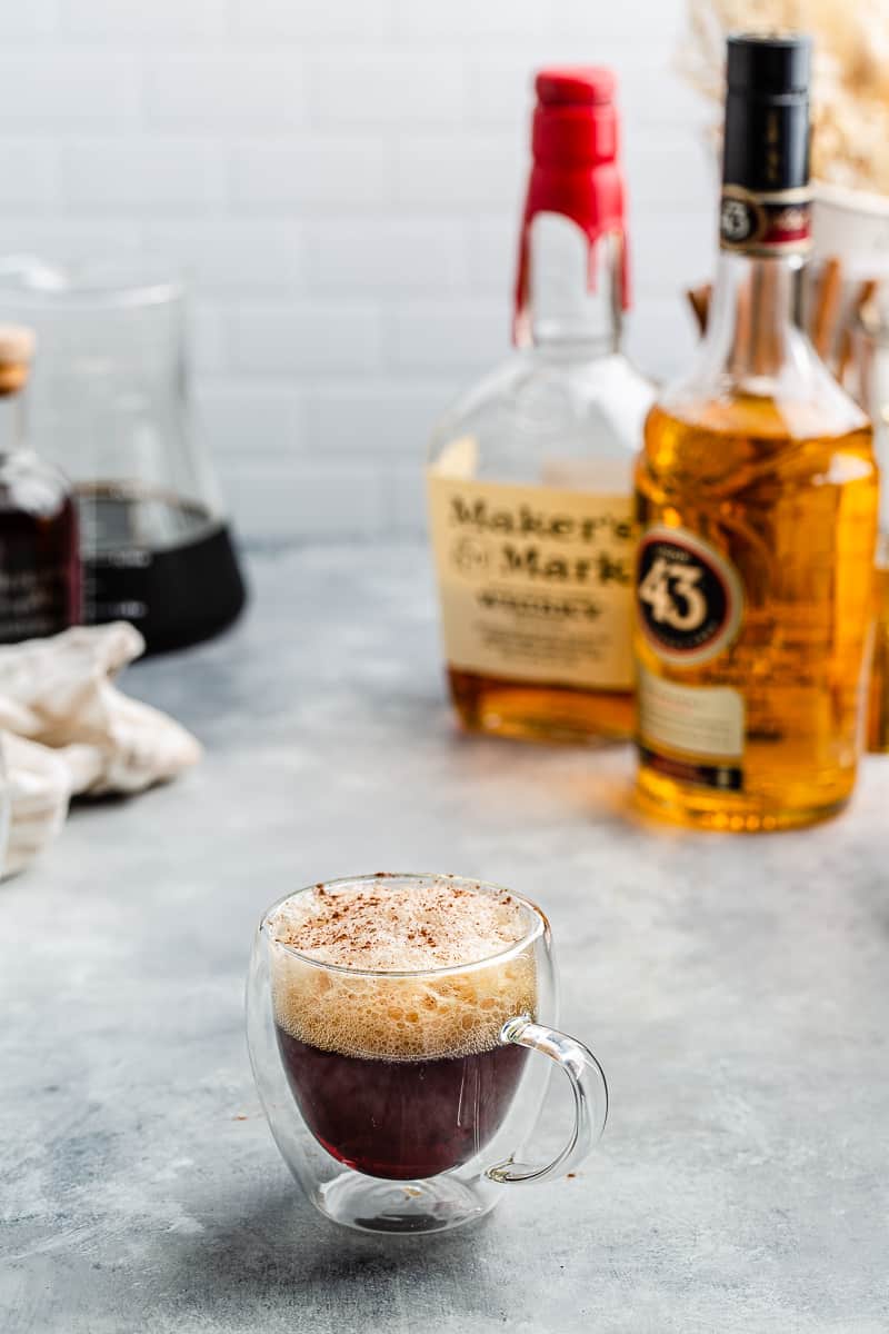 Cold Brew bourbon cocktail in a glass mug with the ingredients in the background