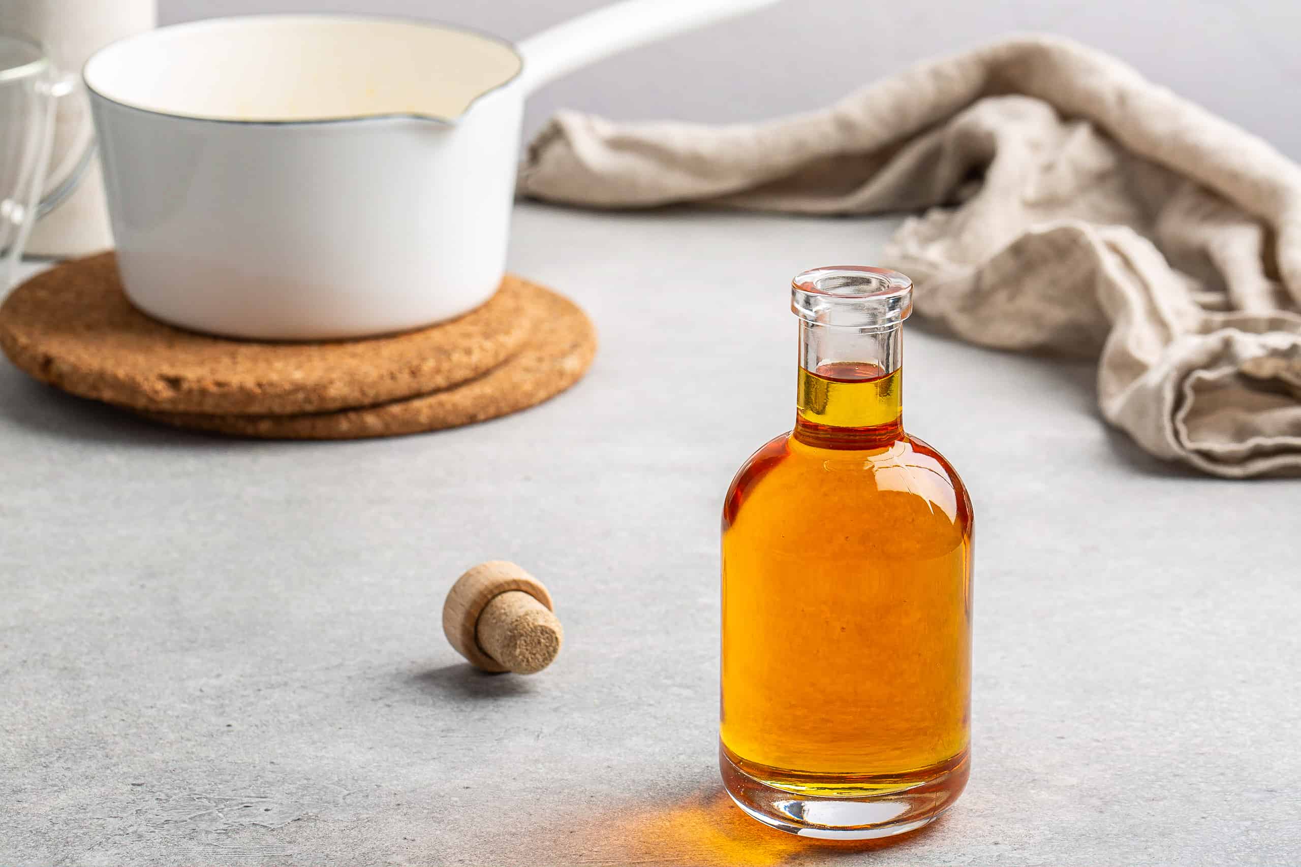 horizontal shot of caramel syrup in a bottle with white pan in background