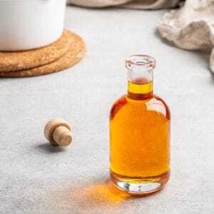 caramel syrup in a bottle with white pan in background