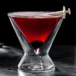 side view of red cocktail in a double-walled martini glass