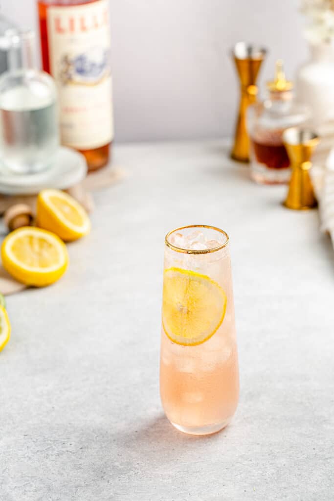 top view of lillet gin cocktail with lemons and other ingredients in the background 