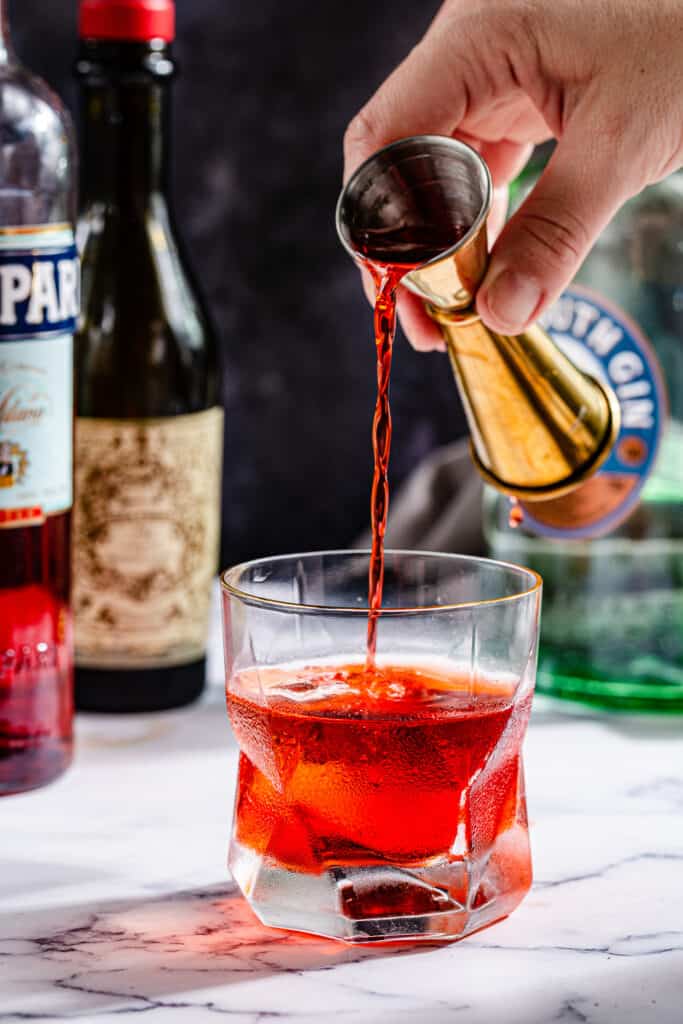 pouring Campari into the cocktail glass