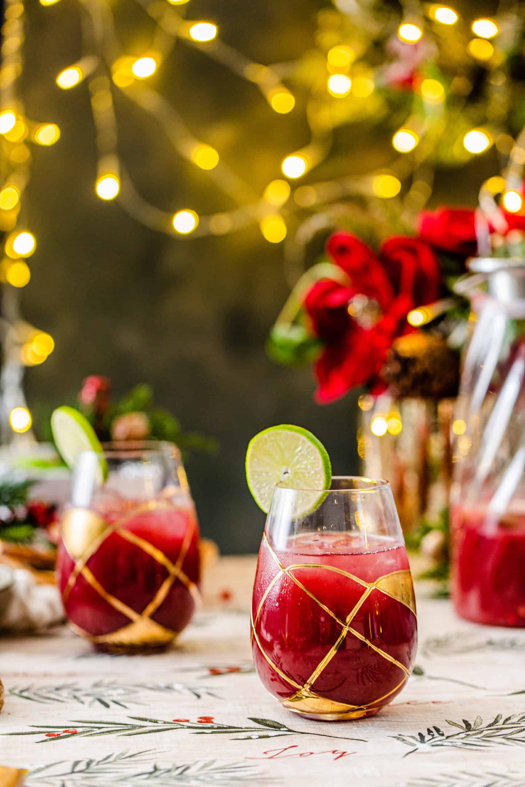 Christmas morning tabletop with red drinks in gold-accented wine glasses