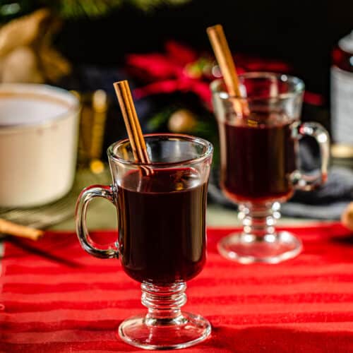 two mugs of mulled wine on a red tablecloth