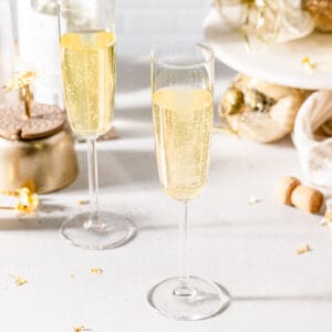 two vodka champagne cocktails for new years eve celebrations with a cork and gold decor