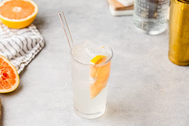 Top view of Grapefruit Rickey with some grapefruits and bar tools in the background.