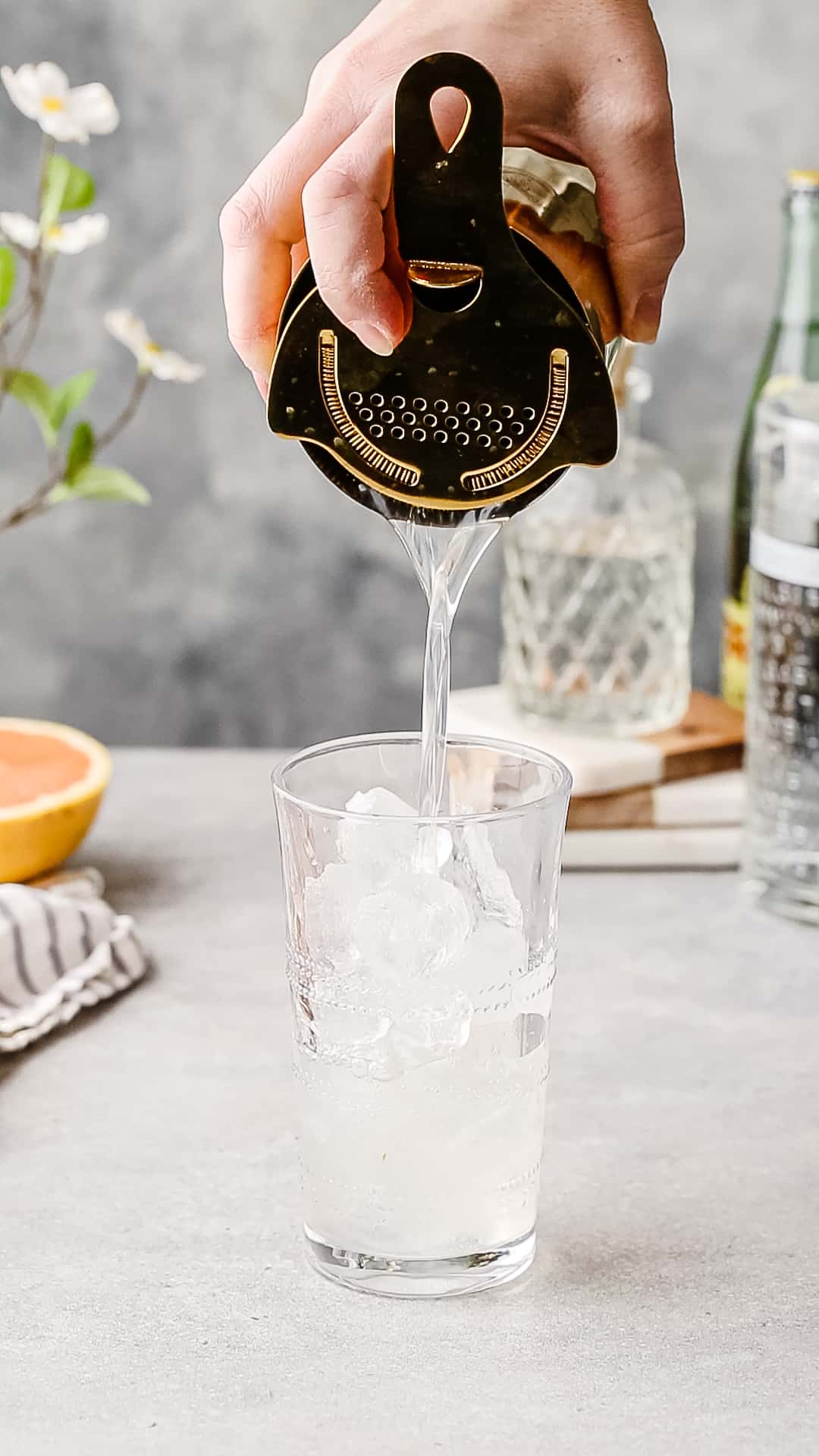 Straining the drink into the serving glass.