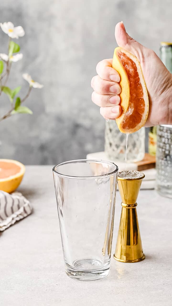 Hand squeezing juice out of a grapefruit.