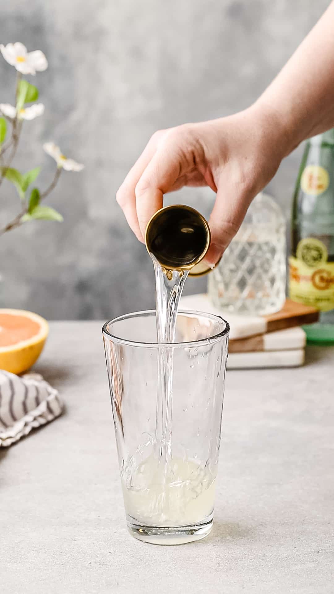 Adding gin to the cocktail shaker.