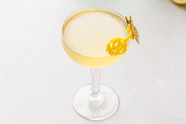 Overhead view of Amaretto French 75 with a lemon peel garnish carved in the shape of a flower.