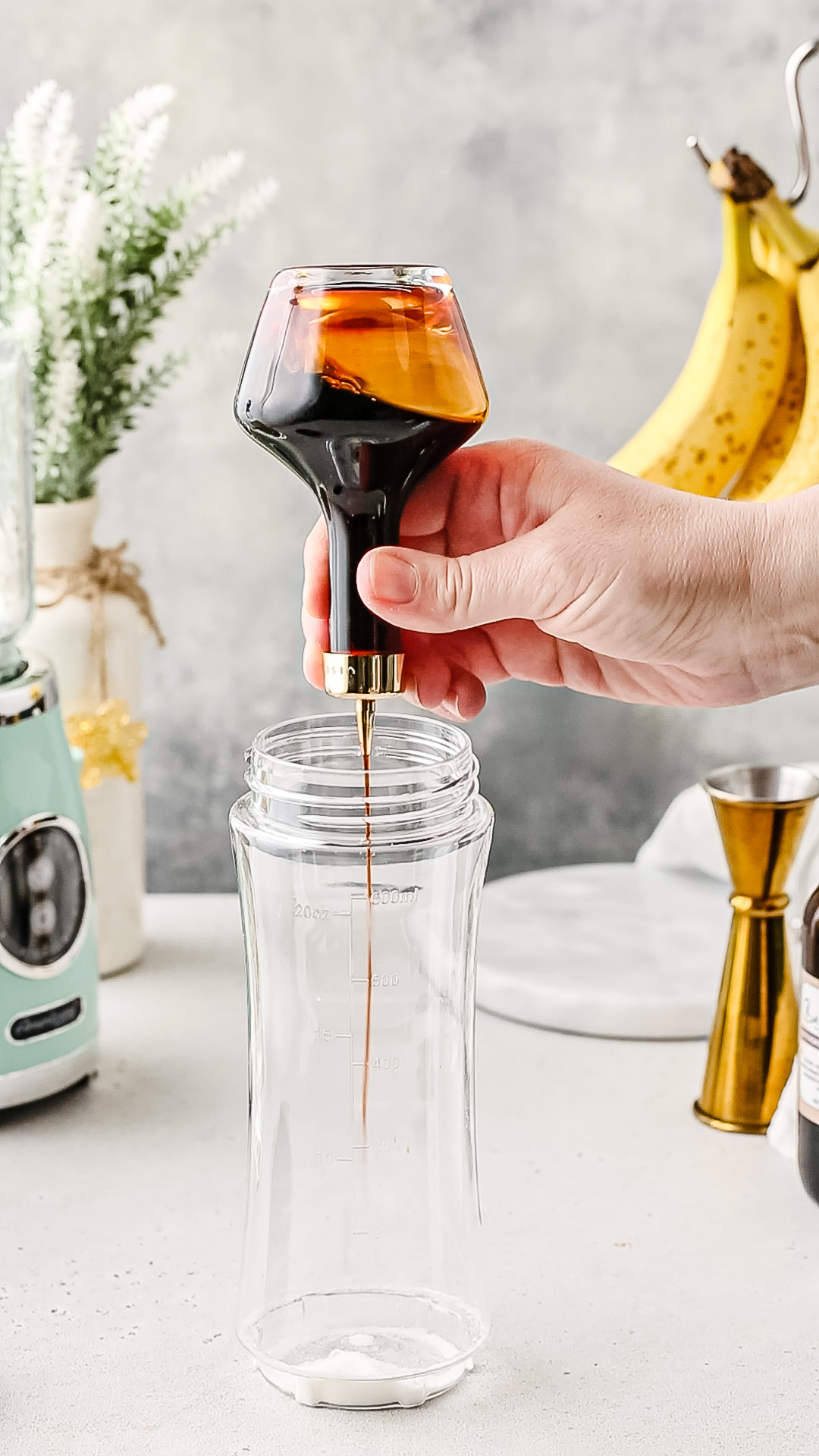 Adding a dash of bitters to a blender cup.