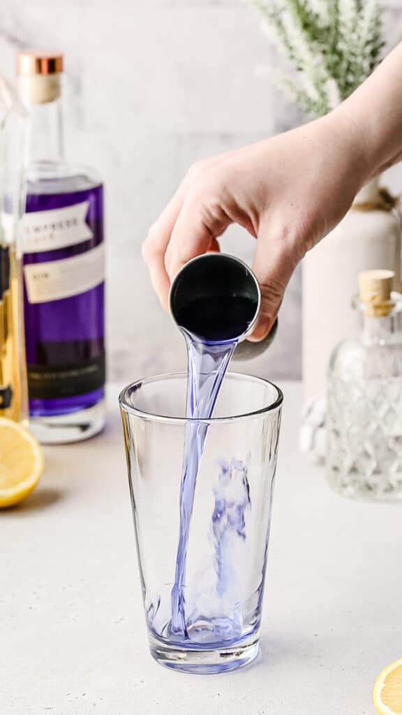 Pouring Empress gin into a cocktail shaker.
