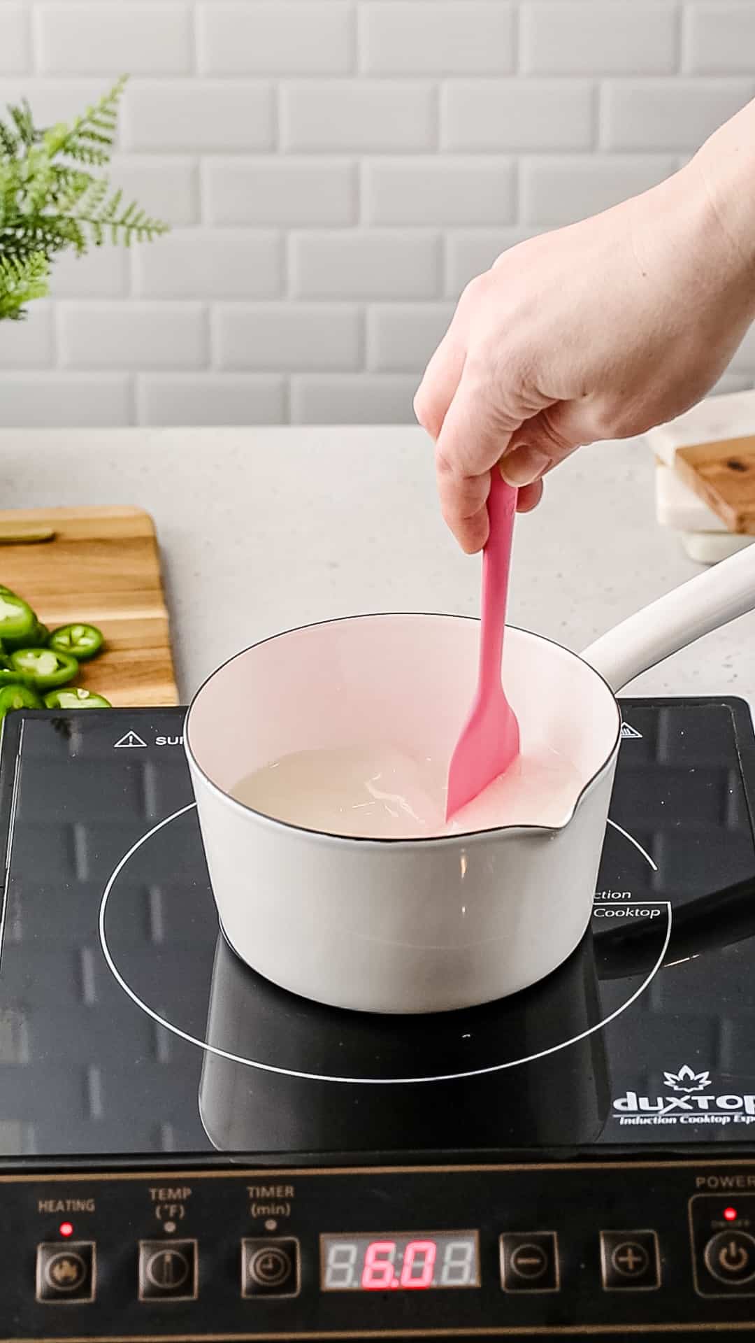Stirring a sugar and water mixture with a spatula.
