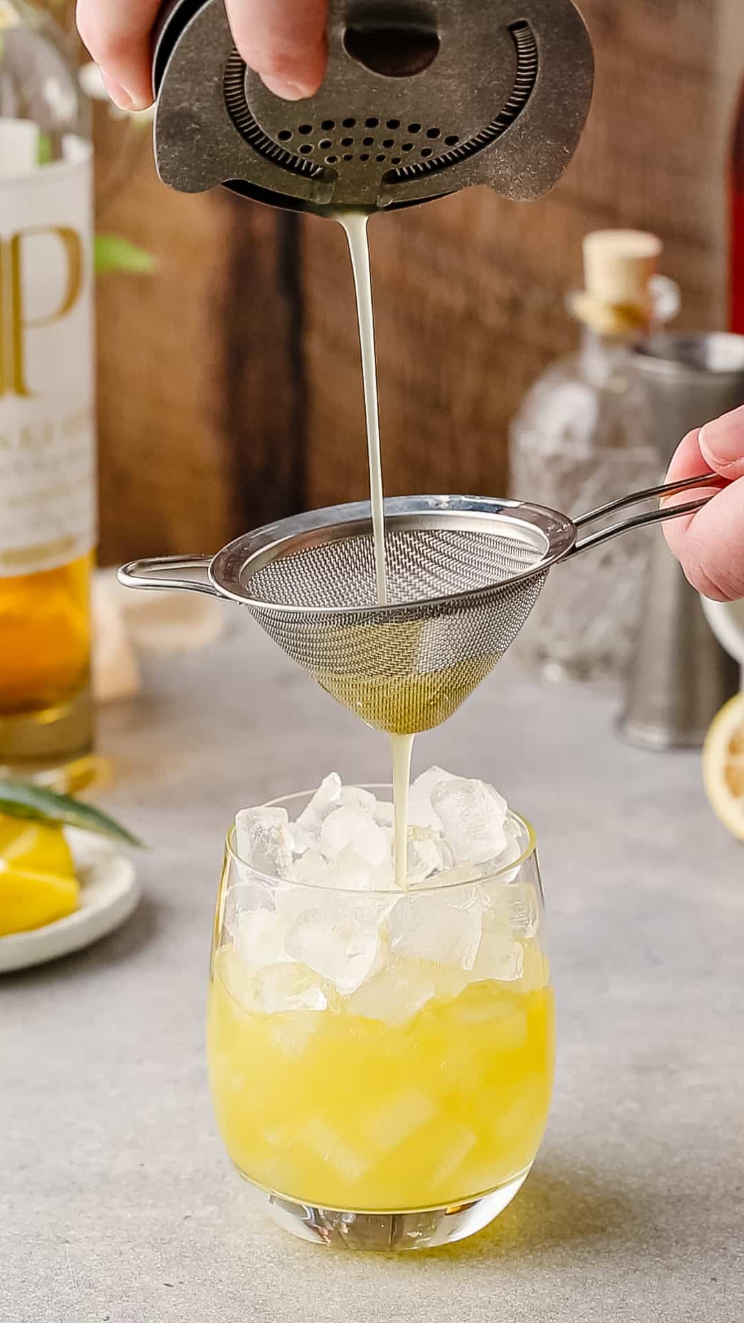 Straining a cocktail into a serving glass.