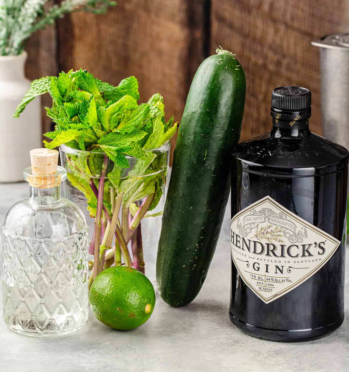 Ingredients needed to make an Eastside cocktail together on a gray countertop.