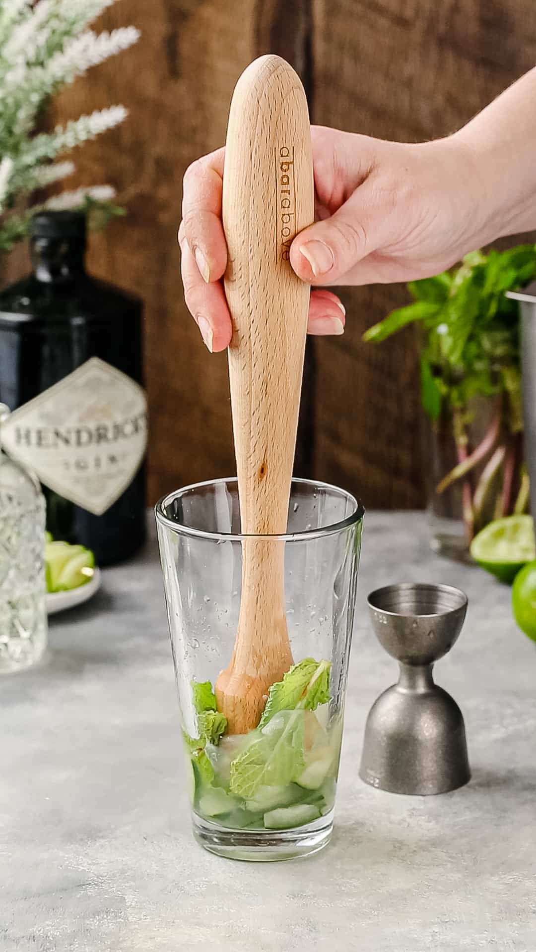 Hand gently muddling fresh mint.