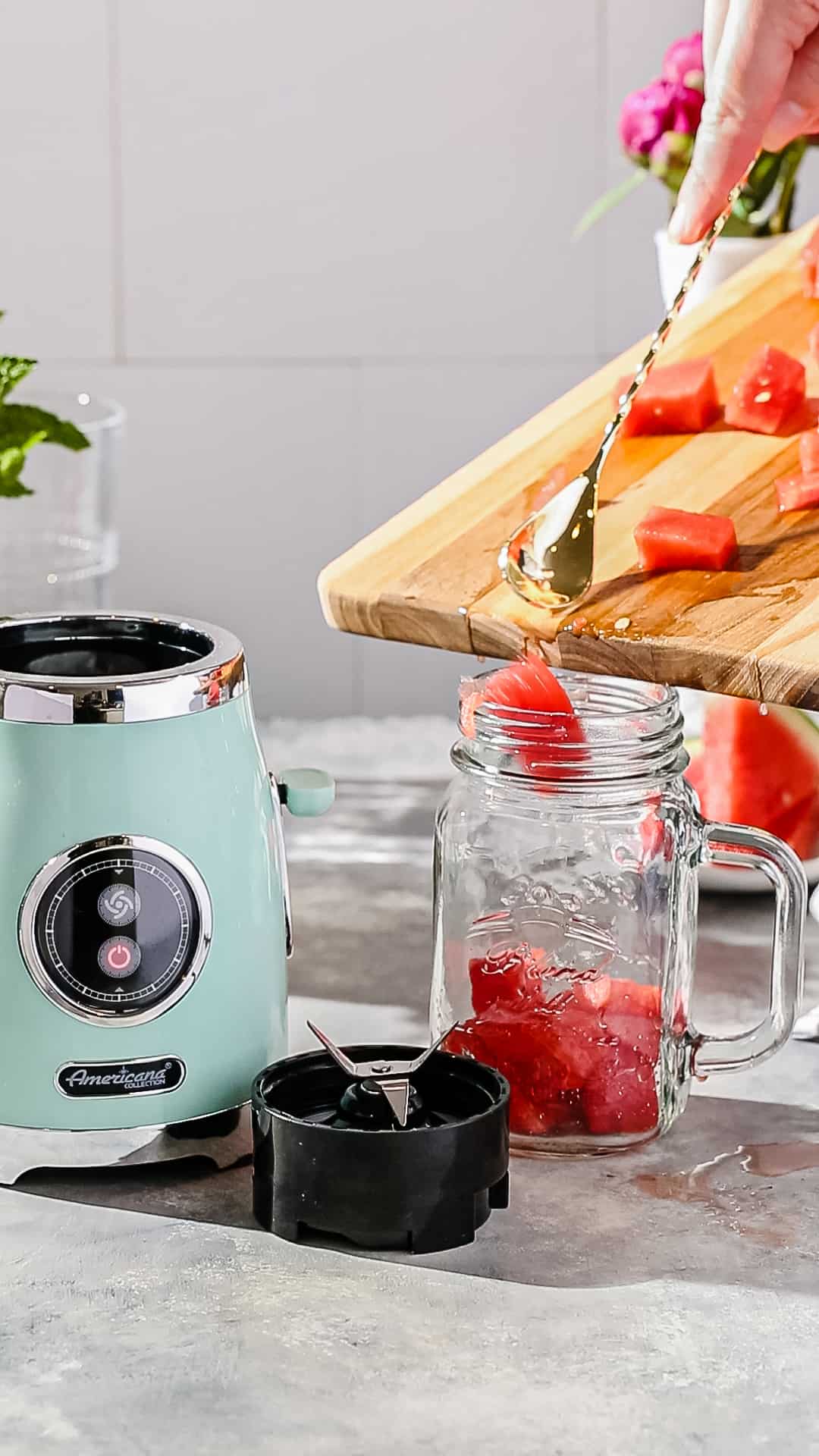 Adding chunks of fresh watermelon to a blender cup.