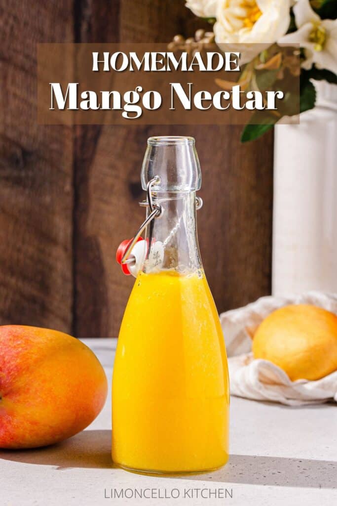 Side view of mango nectar in a glass bottle with mangoes around it and flowers in the background and the text Homemade Mango Nectar above it.