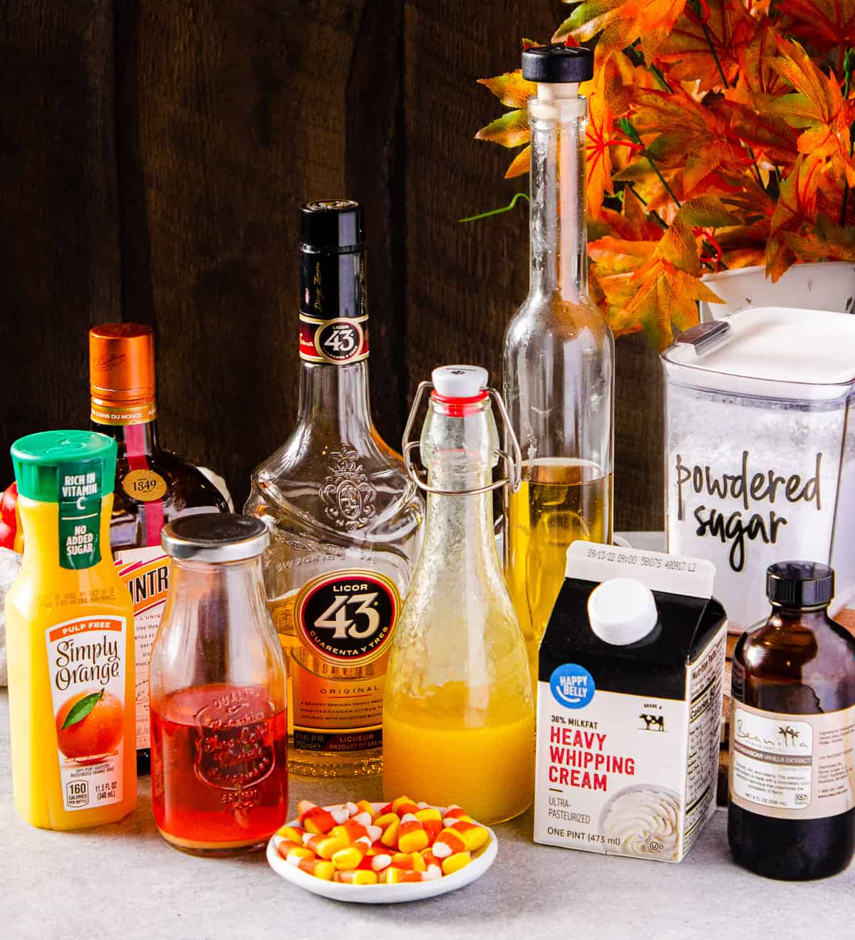 Ingredients to make a candy corn martini all together on a tabletop.