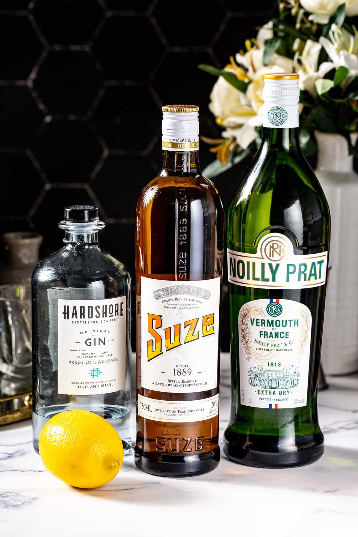 Ingredients needed to make a White Negroni together on a countertop.