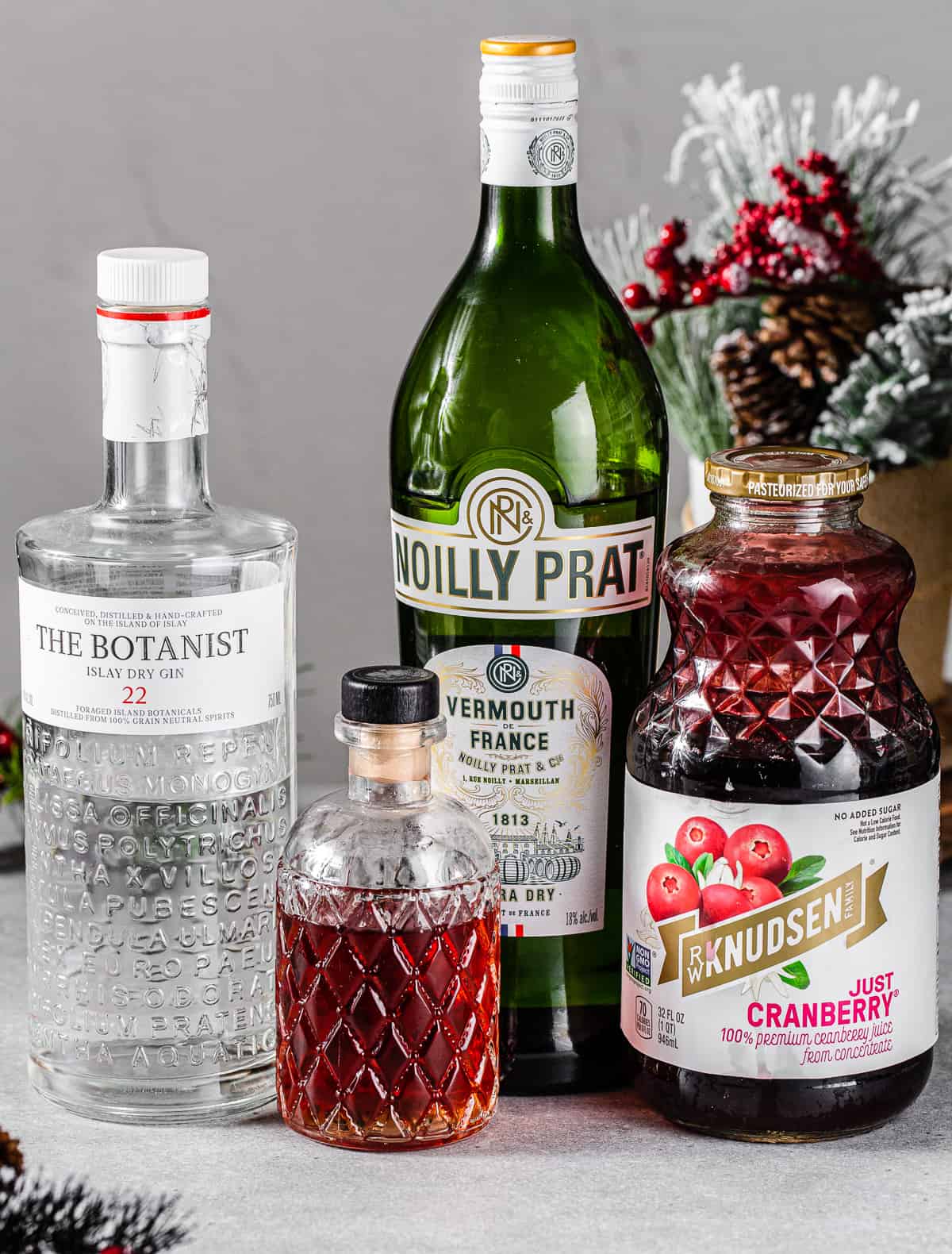 Ingredients to make a Mistletoe Martini cocktail together on a countertop.