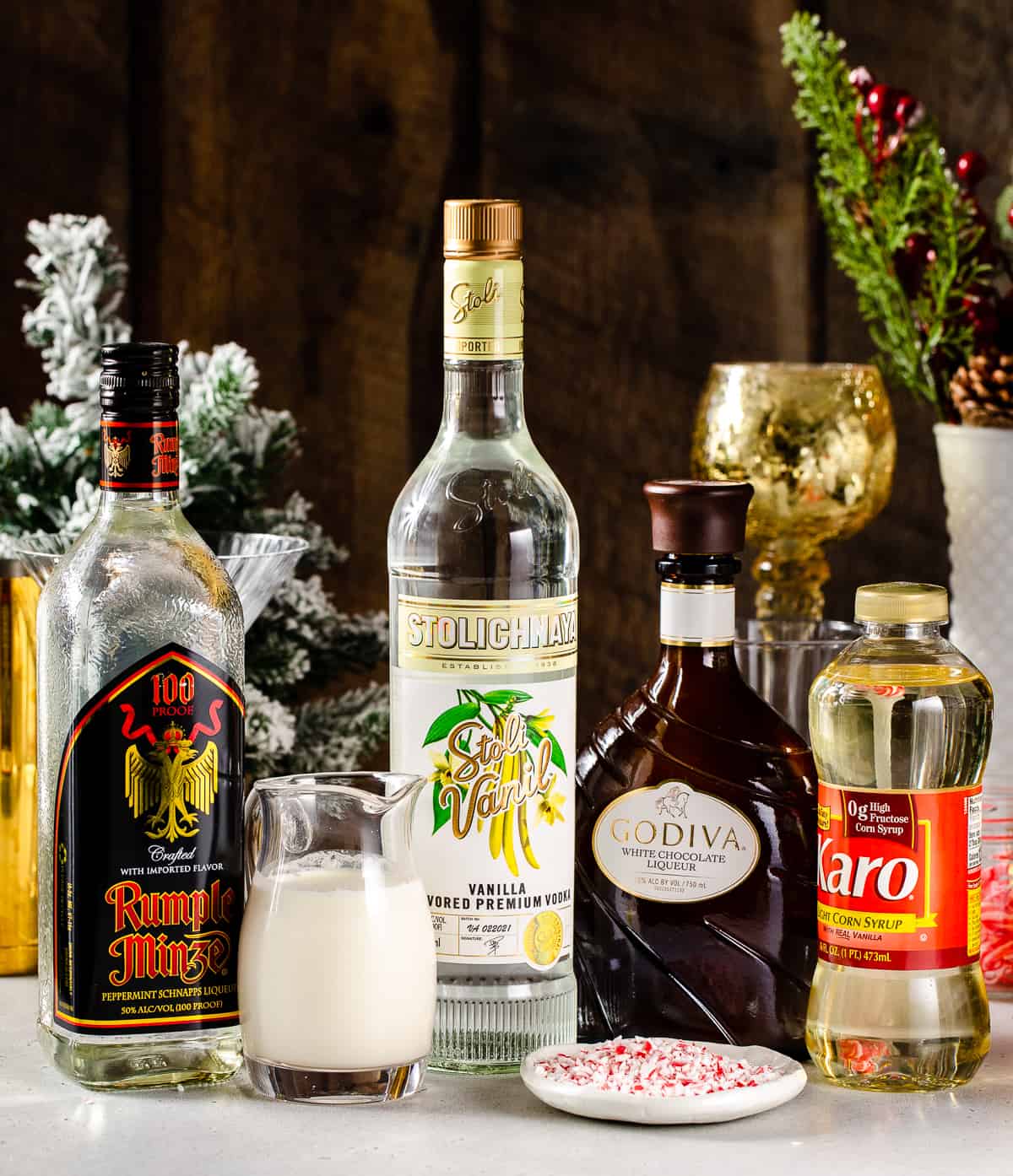 Ingredients to make a Candy Cane Martini cocktail together on a countertop.