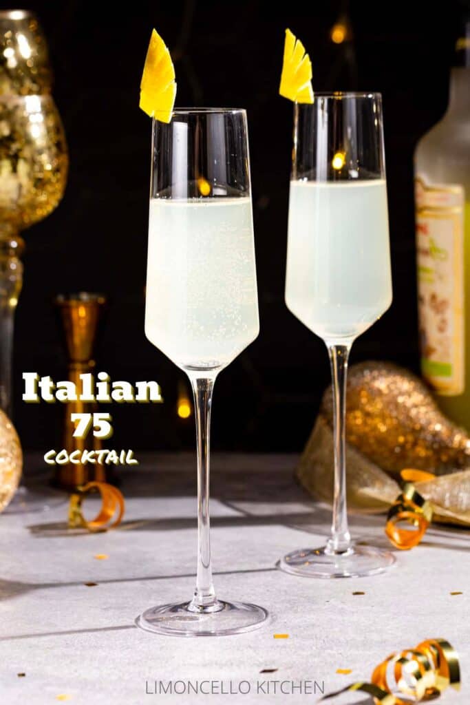 Side view of two Italian 75 cocktails on a gray countertop. The drinks are in Champagne flutes with fancy cut lemon peel garnishes. In the background is a bottle of Limoncello liqueur, along with gold decor and a gold jigger. Gold ribbon curls and gold confetti are on the countertop. Text overlay to the left of the cocktails reads "Italian 75 Cocktail".