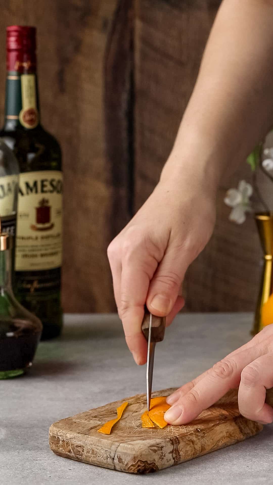 Using a paring knife to clean up the edges of the orange peel.