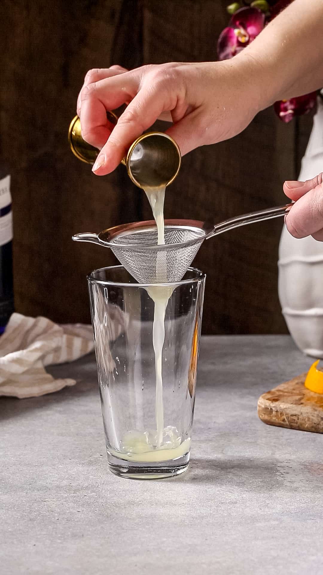 Lemon juice being added to a cocktail shaker glass.