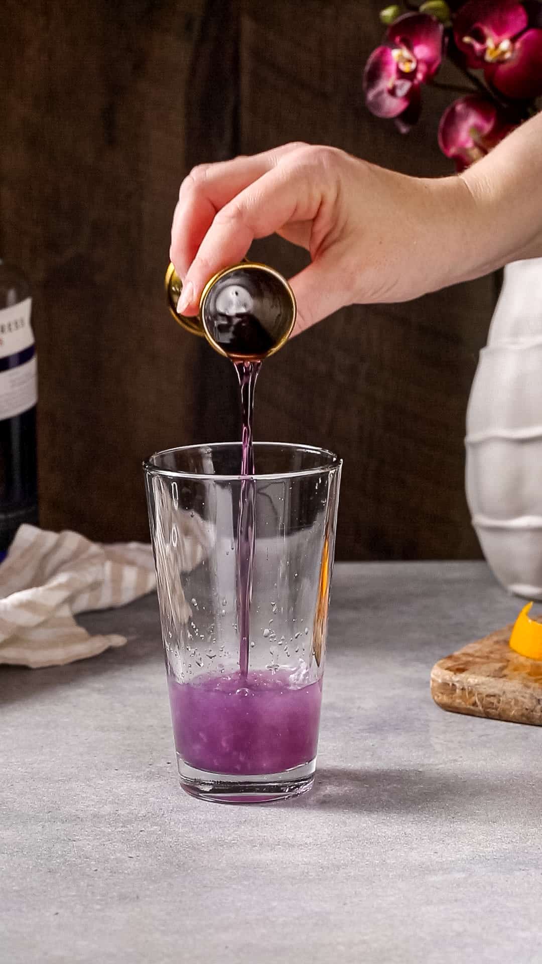 crème de violette being added to the cocktail shaker glass.