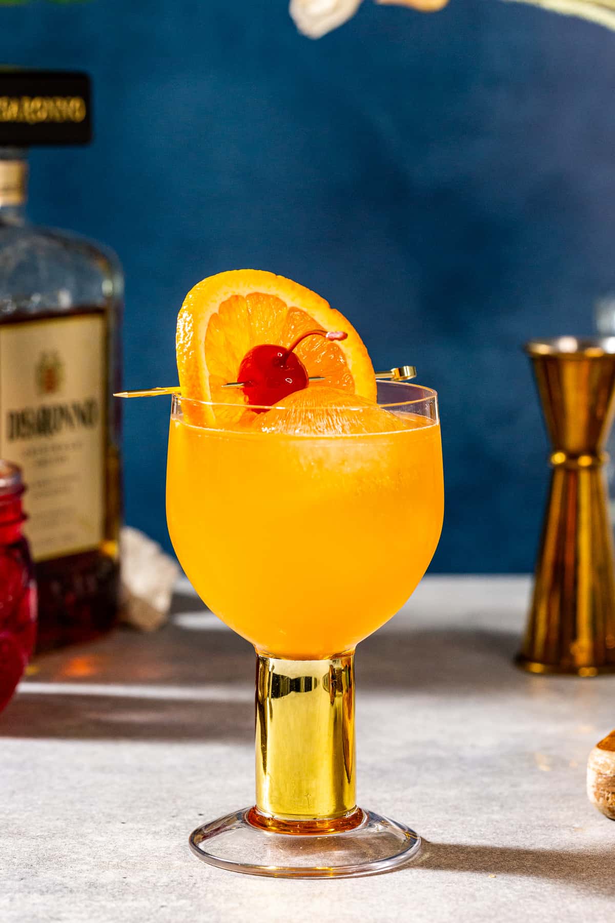 amaretto stone sour cocktail garnished with an orange and a cherry.