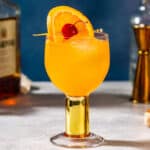 amaretto stone sour cocktail garnished with an orange and a cherry.