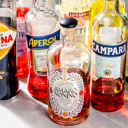 Close up of a variety of different bottles of amaro liqueur.
