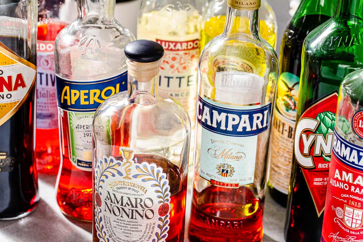 Close up of a variety of different bottles of amaro liqueur.