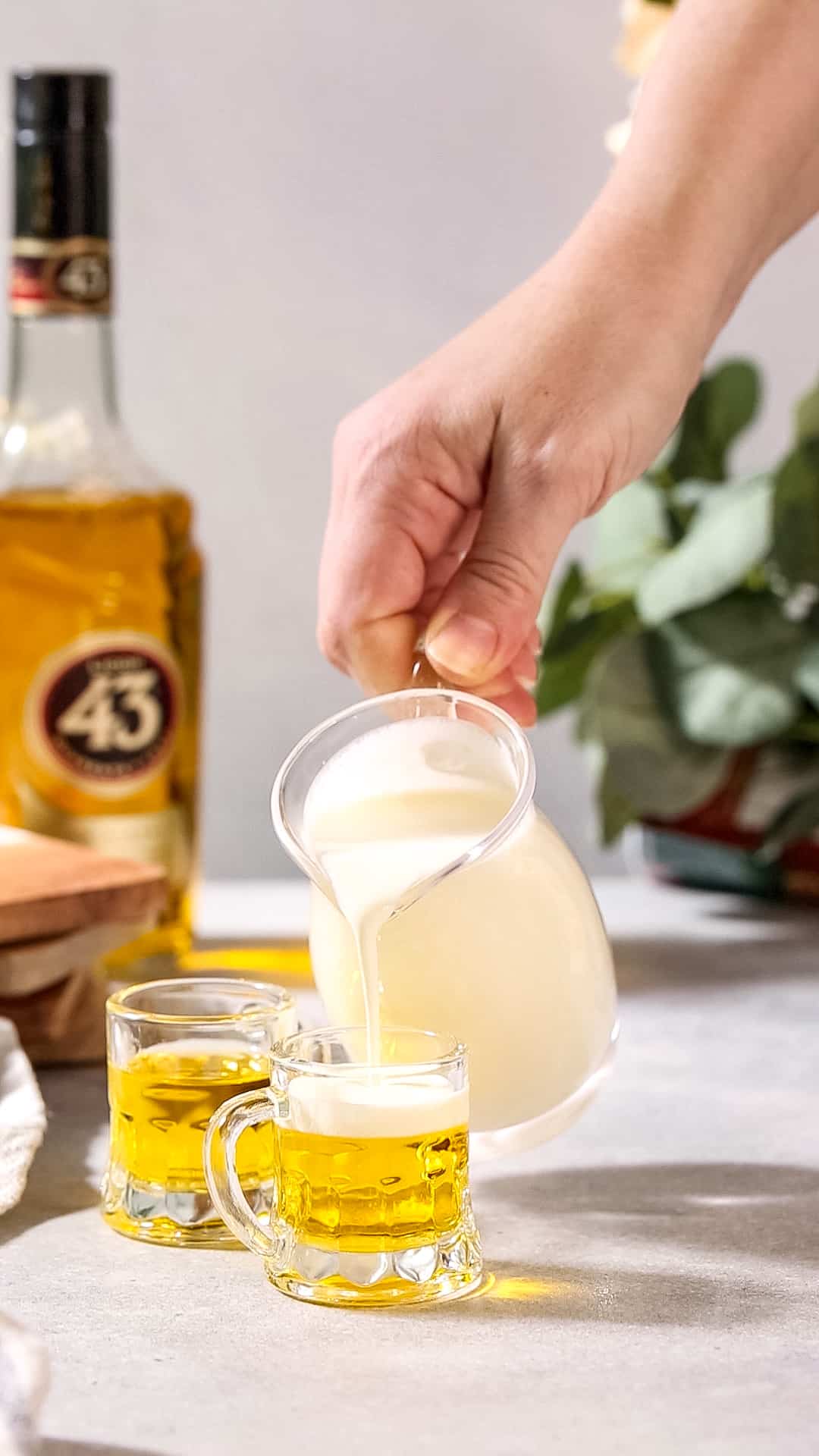Heavy cream being poured over top of the little beers shots.