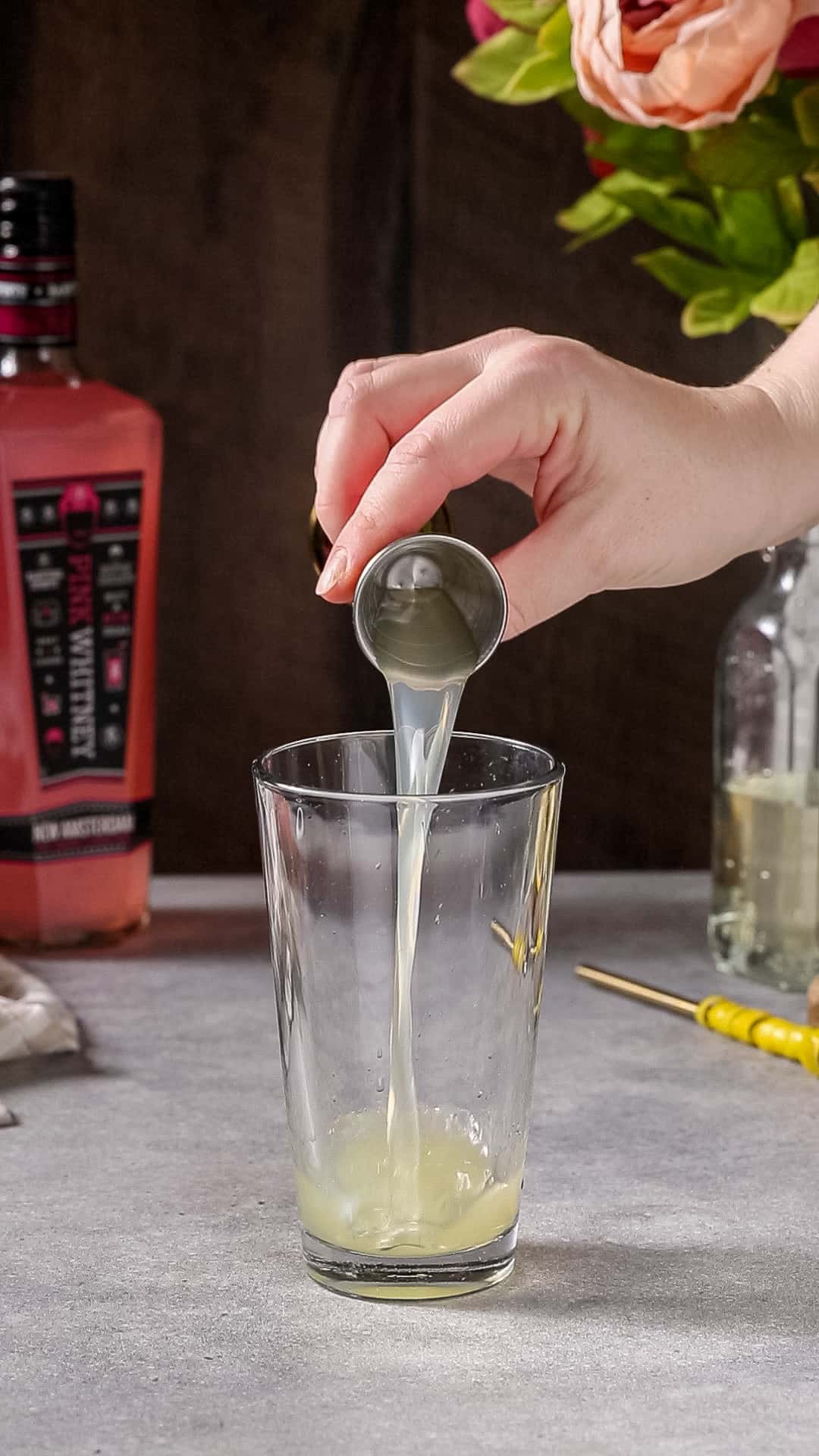 Lemon juice being added to the mixing glass.