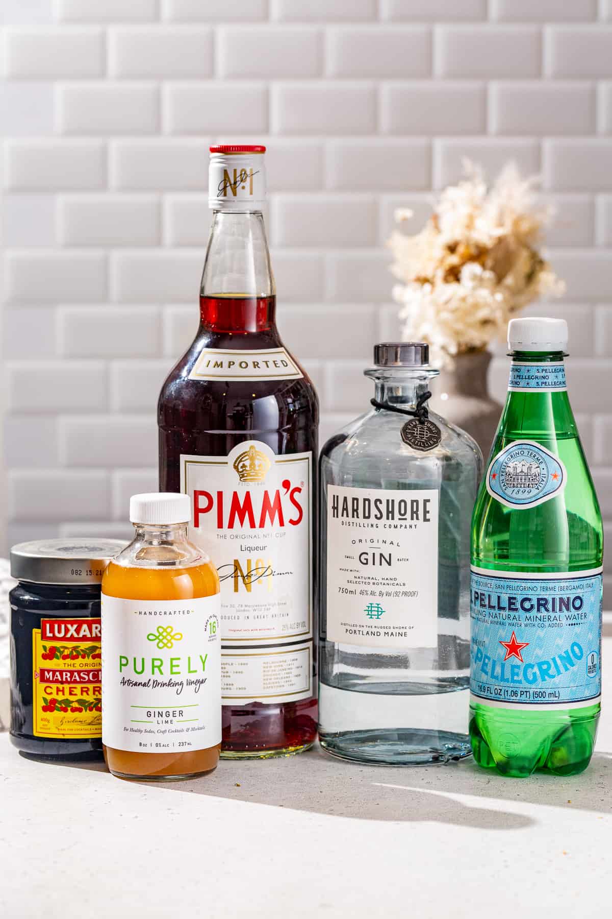 Ingredients to make a shrub cocktail together on a countertop.